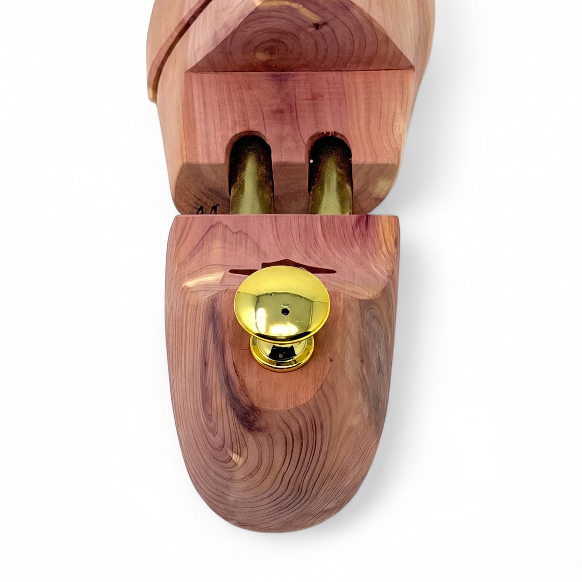 Close-up detail of ergonomic brass heel knob and dual spring-loaded tubes on cedar shoe tree
