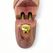 Close-up detail of ergonomic brass heel knob and dual spring-loaded tubes on cedar shoe tree