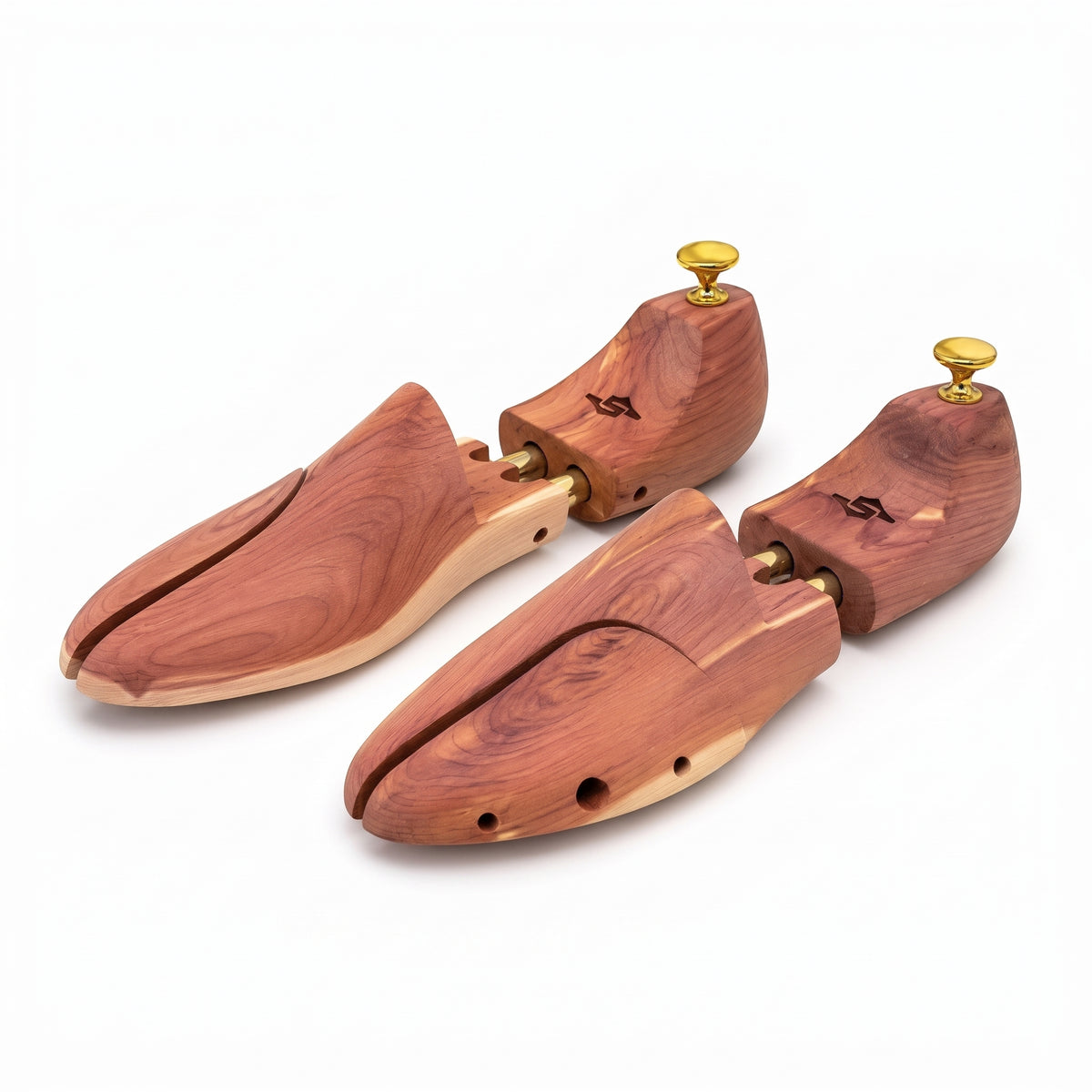 Pair of adjustable aromatic cedar wood shoe trees with gold brass heel knobs on white background